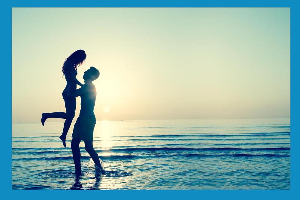 una pareja en la playa disfrutando del amor